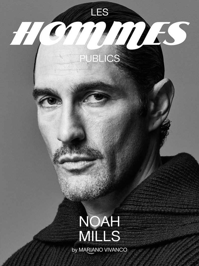 Black and white portrait of Noah Mills for magazine cover, wearing dark knit sweater. Les Hommes Publics text visible.