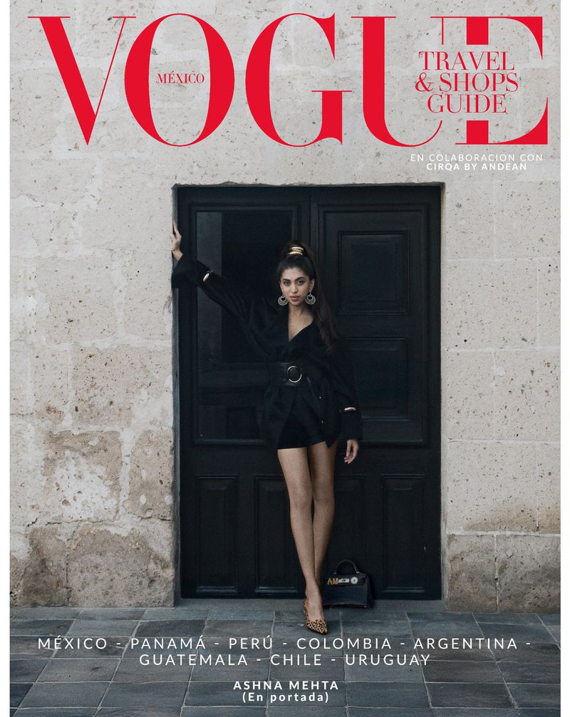 Vogue Mexico magazine cover featuring a young woman in a black dress, posing in front of a dark door with stone wall background.