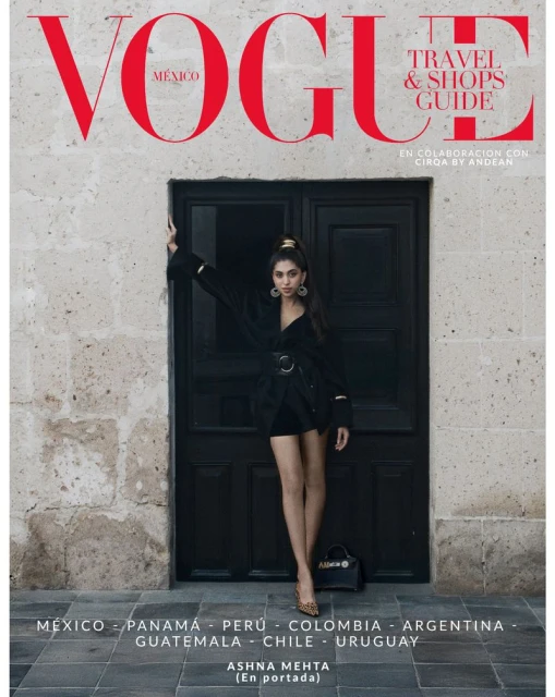Vogue Mexico magazine cover featuring a young woman in a black dress, posing in front of a dark door with stone wall background.
