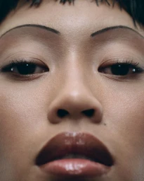 Close-up beauty portrait of model Lotte Kleihauer featuring glossy lips, thin arched eyebrows, and dewy skin for Tush Magazine.