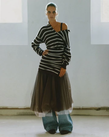 Model Suzie Bird wearing a striped off-the-shoulder knit top, sheer tulle skirt, and wide-leg denim jeans.