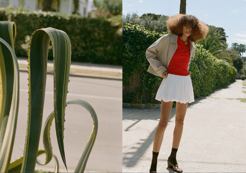 Woman in red top and white skirt standing on sunny path alongside green agave plant and hedging in outdoor fashion editorial shot.