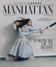 Lucy Liu poses dynamically holding a paintbrush wearing a Balenciaga denim jacket and full skirt on the Modern Luxury Manhattan cover.