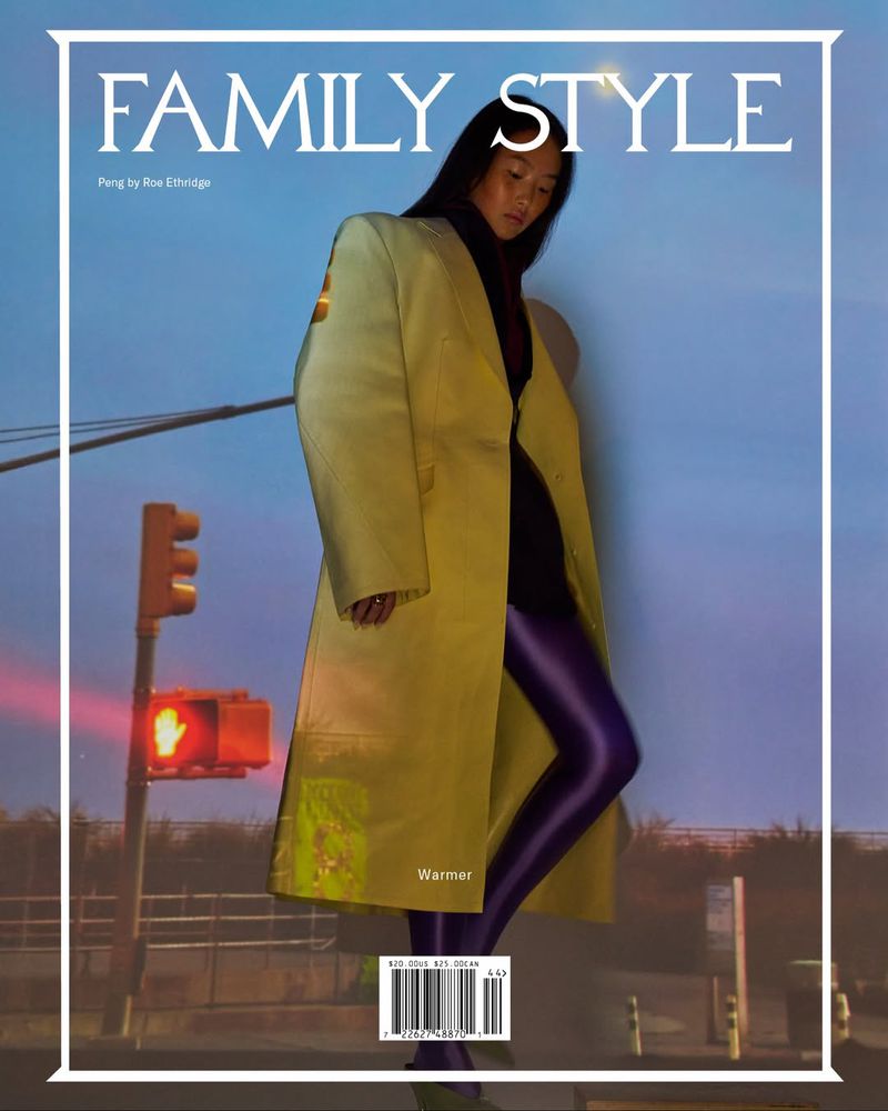 Fashion magazine cover featuring an Asian adult female model in a long yellow coat, purple leggings, traffic lights in the background.