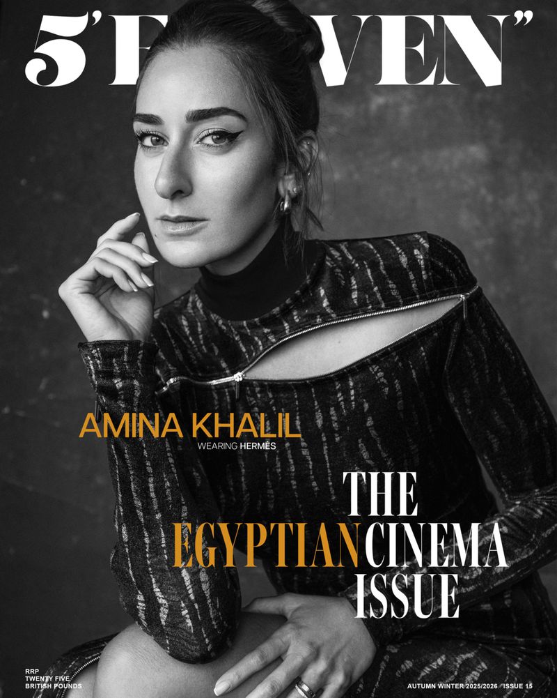 Portrait of Amina Khalil on a magazine cover; features the actress in a high-necked dress with a black and white background.