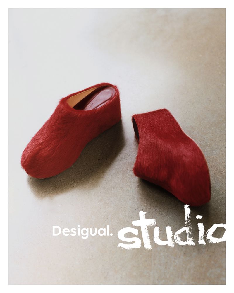 Two red, furry Desigual Studio heeled shoes displayed in a minimalist fashion product shot on a neutral surface with soft, diffused lighting.