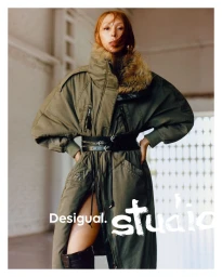Issa Lish wearing an olive green belted coat with fur collar in Desigual Studio FW25 campaign editorial.