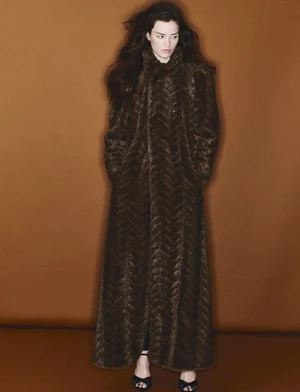Model Niamh Battersby in a long brown patterned coat against a brown studio background for 10 Magazine Australia.