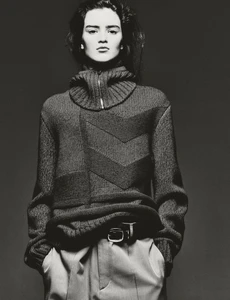 Model Niamh Battersby wearing a high-neck patterned knit sweater in a black and white editorial portrait.