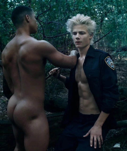 Two men in an outdoor setting: one shirtless, one in a uniform, engaging in an implied confrontation or interaction within a wooded area.