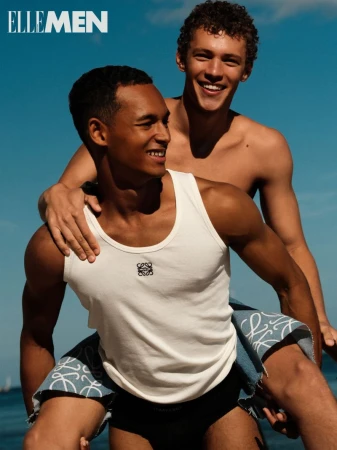 Two male models posing outdoors against a clear blue sky for an Elle Men Thailand editorial shot by Julian Freyberg
