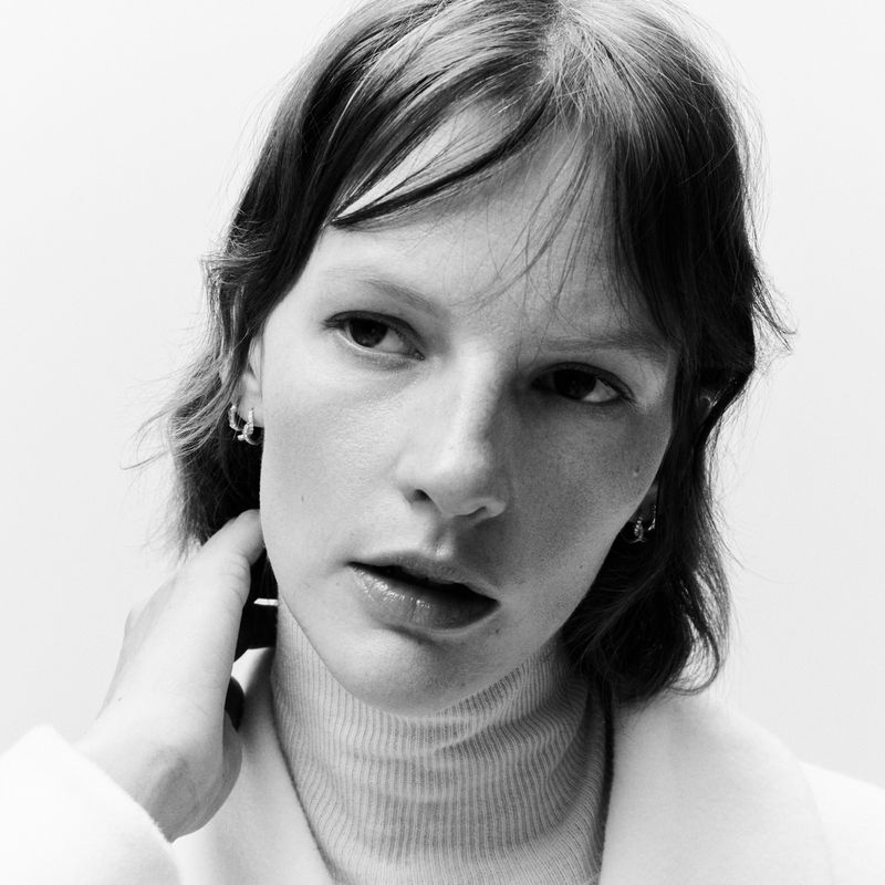 Close-up portrait of model Sara Blomqvist wearing a high-neck top against a plain light background for Fabiana Filippi FW 2025.