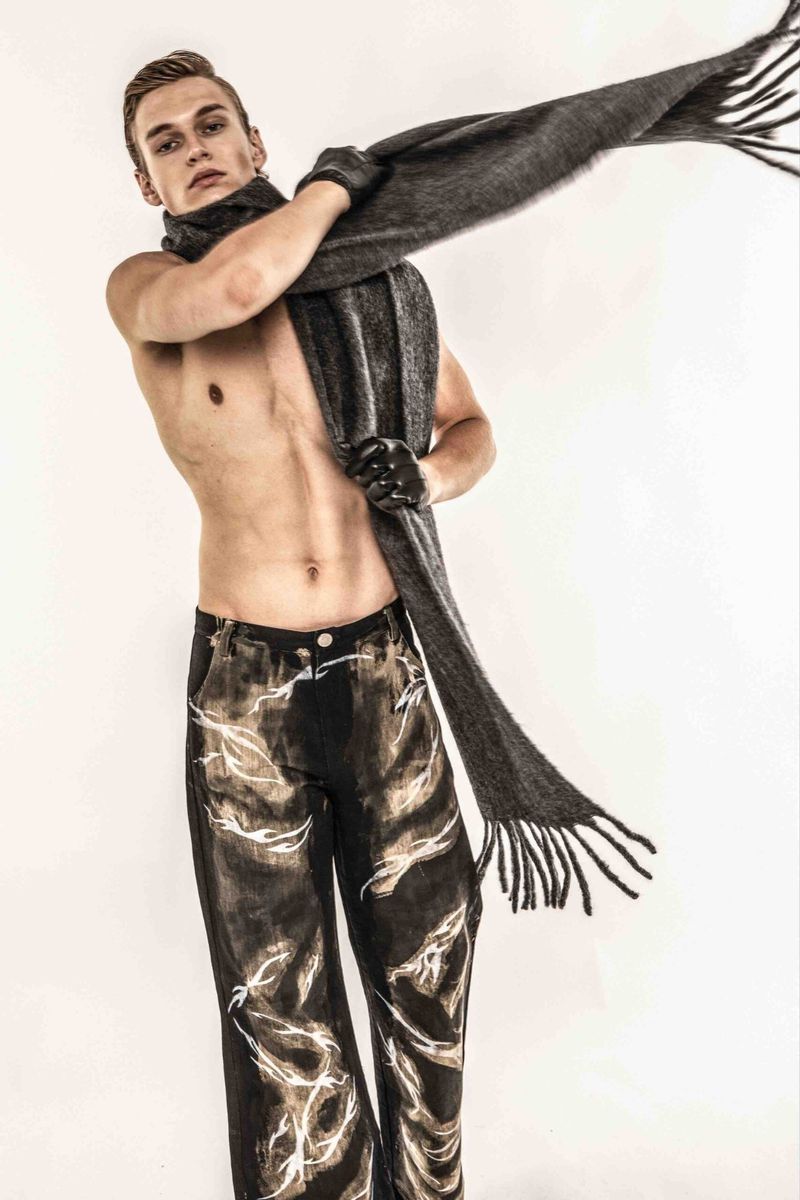 Topless man with a scarf in a studio, wearing painted trousers, fashion, studio lighting, portrait photography, studio background.