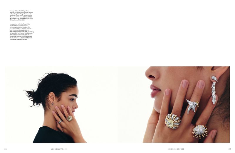 Close-up of two women showcasing luxury jewelry: rings, and earrings, against a bright white background. Jewelry, fashion and beauty.