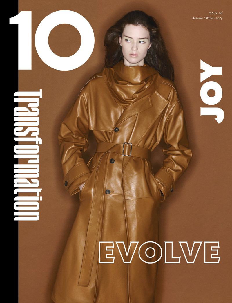 Fashion magazine cover featuring a female model in a brown leather trench coat, set against a matching brown backdrop with white text.