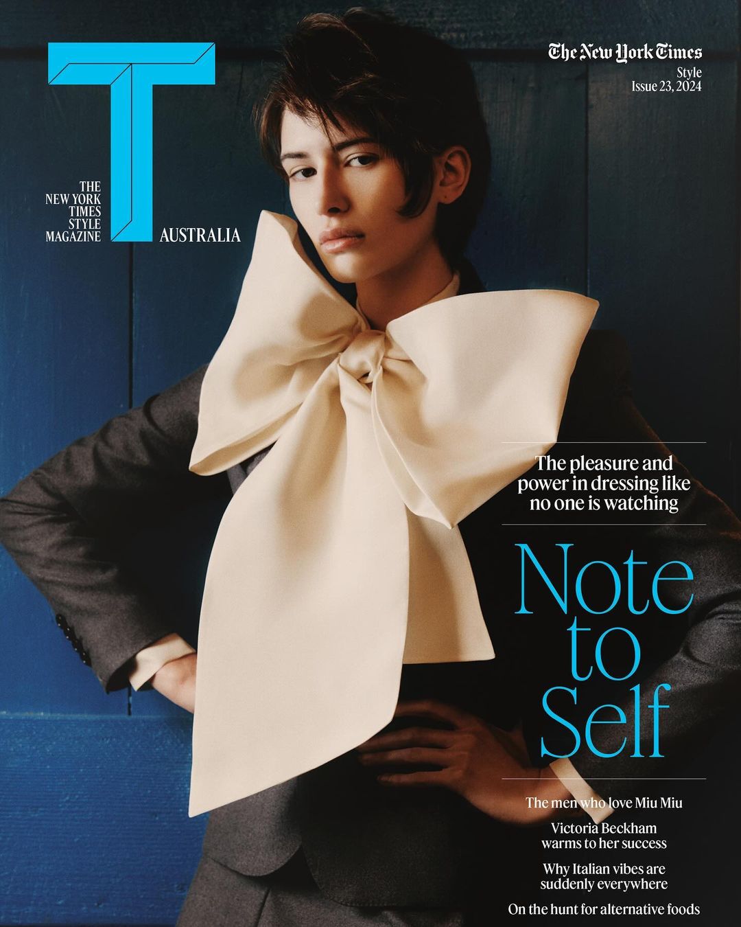 Magazine cover featuring a person in a suit with a large bow tie, standing against a blue wall. The New York Times Style Magazine.