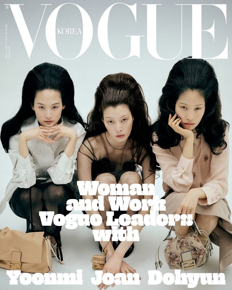 Three women with dark hair pose for a Vogue Korea magazine cover. The models are seated, wearing blouses, and accessorized with purses.