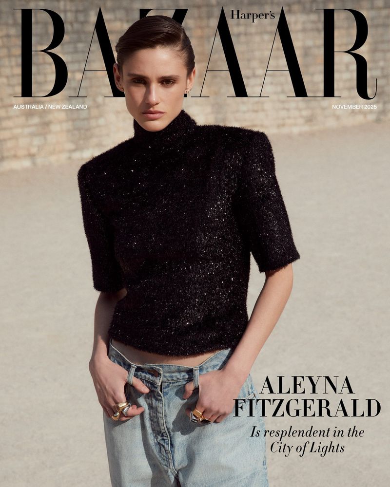 Fashion magazine cover featuring a woman with short hair in a black top and jeans, posing outdoors against a neutral wall.