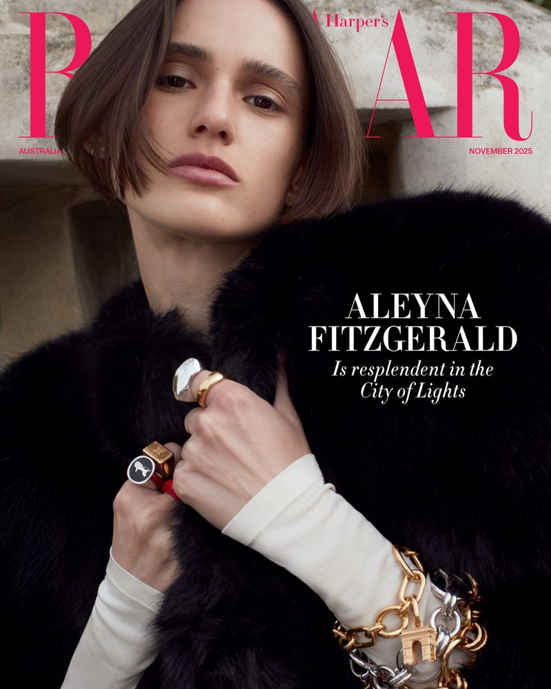 Harper's Bazaar cover featuring a model wearing a black fur coat and jewelry, with magazine text overlayed on a neutral stone background.