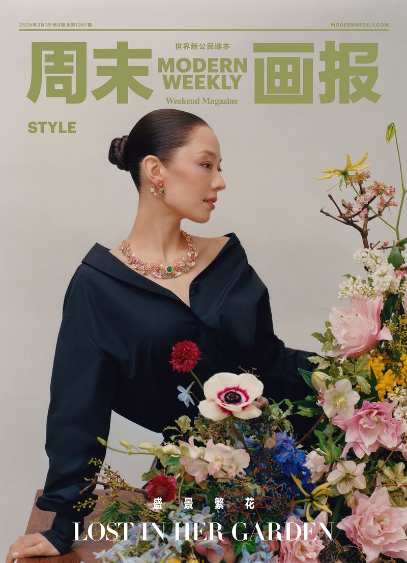 Elegant woman with jewelry and flowers on a magazine cover; Modern Weekly Style featuring a woman in dark top and colorful flowers.