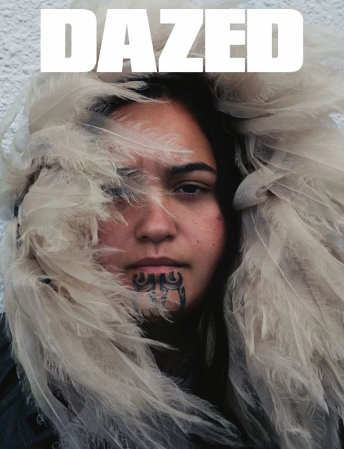 Dazed magazine cover with an Indigenous woman's portrait framed by feathered elements and featuring a traditional face tattoo.