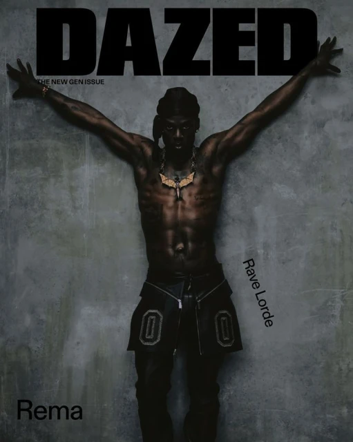 Rema poses for a Dazed magazine cover with his arms outstretched against a textured gray background, adorned with a gold necklace.