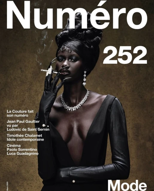 Magazine cover featuring a dark-skinned female model smoking, wearing a black dress, statement jewelry, and an elaborate updo hairstyle.