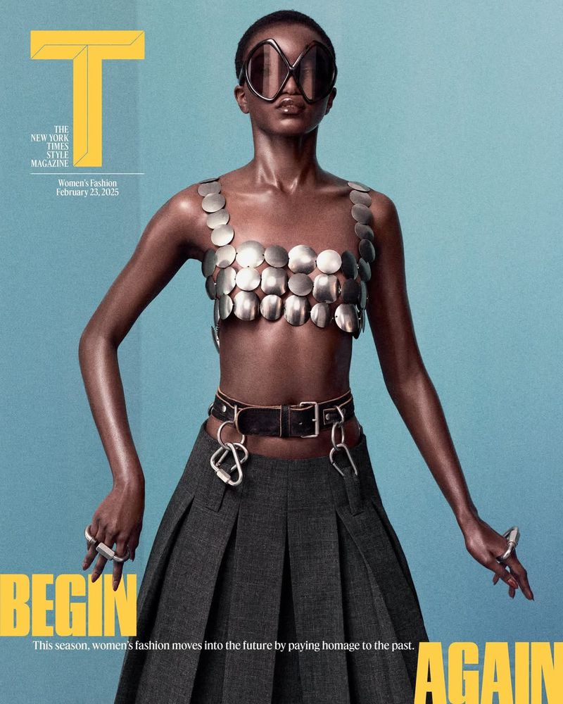 Model wearing metallic disc top and pleated skirt with oversized sunglasses against a solid teal background
