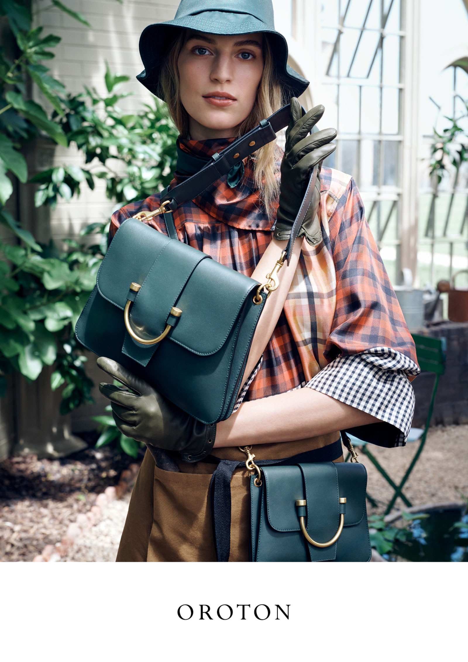 Model wearing dark green hat and gloves holding a matching leather handbag for Oroton Autumn campaign