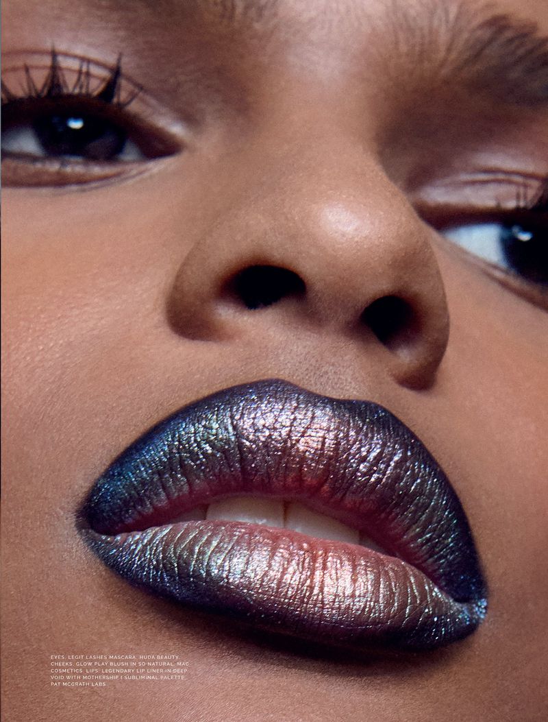 Close-up of a woman's face with striking multicoloured lipstick, long eyelashes, and clear skin. Beauty shot focused on makeup.