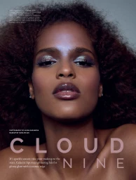 Close-up beauty editorial portrait of a Black woman with voluminous curly hair, shimmering eyeshadow, and high-shine glossy lips.