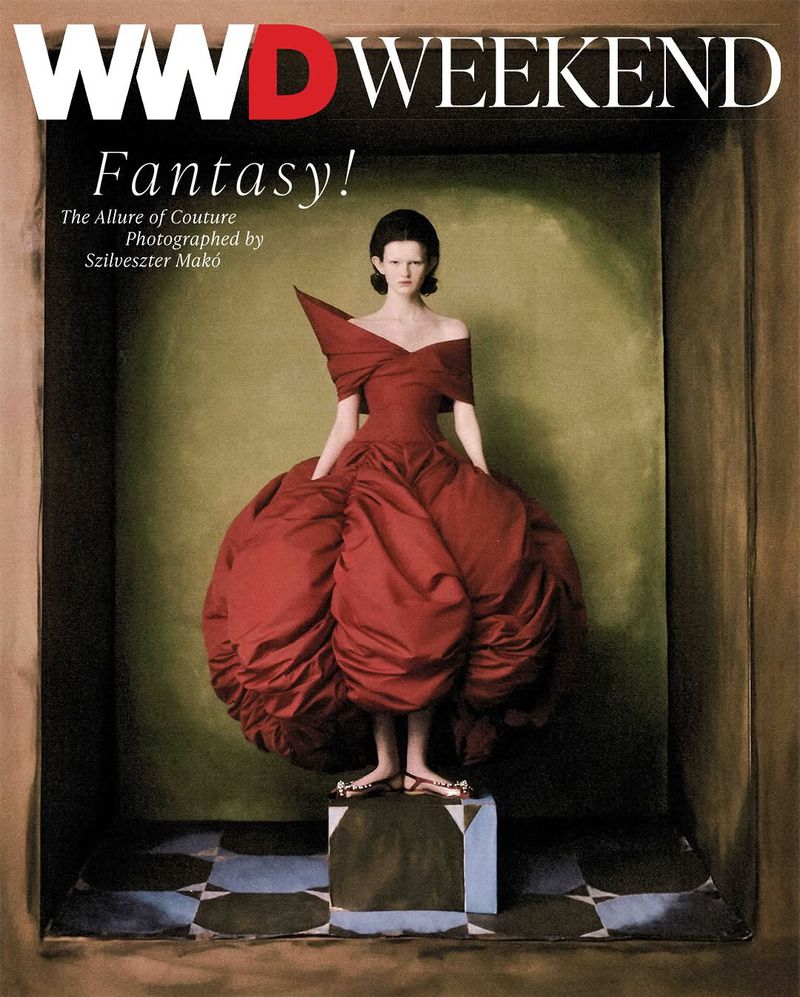 Fashion editorial featuring a model in a red couture dress and minimalist background. The image is a magazine cover.