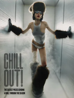 Model Eva Komuves posing in a silver tank top, underwear, oversized furry boots, fur cuffs, and a trapper hat surrounded by cold vapor.
