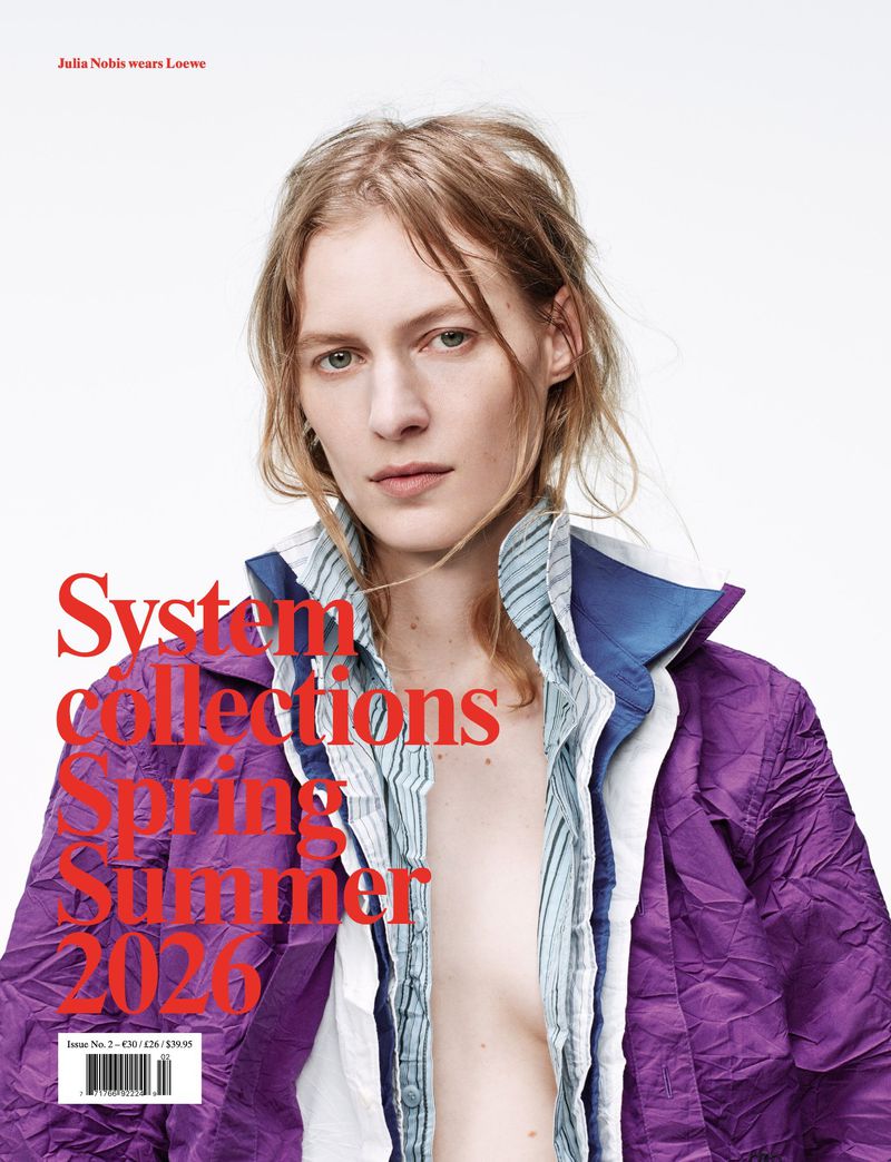 Fashion magazine cover featuring a fair-skinned adult woman in a purple jacket, captured in a medium shot against a white background.