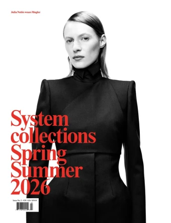 Fashion magazine cover featuring a fair-skinned woman with slicked-back hair wearing a black Mugler suit against a white backdrop.
