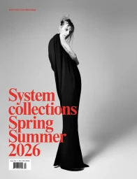 Model Julia Nobis wearing a long black dress standing against a grey seamless background for System Magazine.