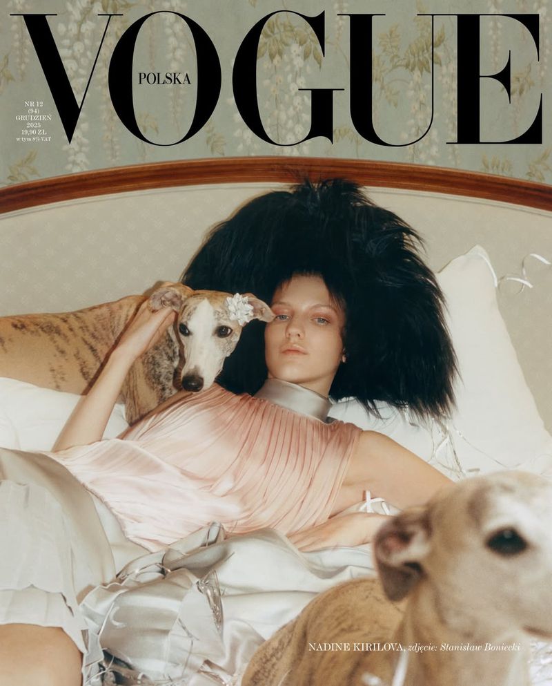Magazine cover featuring a woman reclining on a bed with two dogs, showcasing fashion and editorial style with a vintage aesthetic.