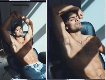 Model Iago Botelho seated in a black leather chair with arms raised, illuminated by natural sunlight for an exclusive MMScene interview.