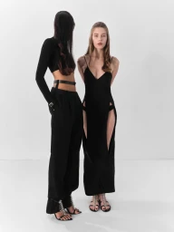 Two models posing in black cutout and tailored garments against a white seamless studio backdrop for Beyond Noise.