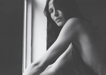 Black and white portrait of model Jeanne Cadieu posed near a window for the Ladybird project.