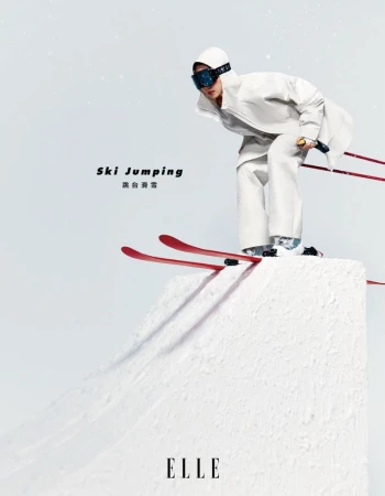 Fashion shot of a person in white ski gear, poised for ski jumping on a snow ramp, against a white background in a studio environment.