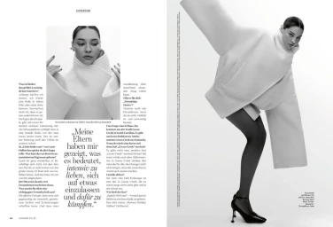 Madelyn Cline in an oversized sculptural white jacket, dark tights, and high heels in a Glamour Germany magazine spread.