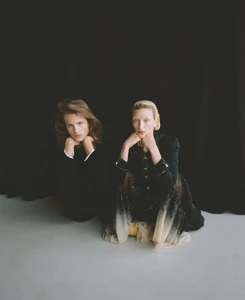 Two models posing against a dark backdrop in editorial fashion portraiture for ODDA Magazine.