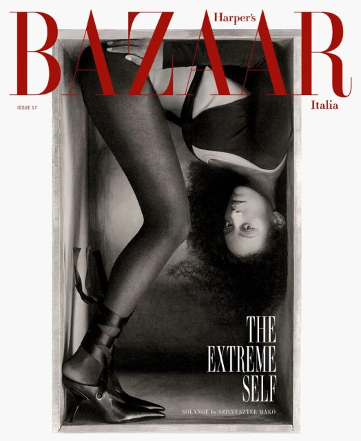 Harper's Bazaar Italia magazine cover featuring a Black woman in black attire posed inside a box with a shoe, artistic lighting.