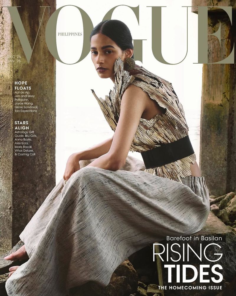 Vogue Philippines cover featuring a woman in an ornate gold top and light-colored skirt sitting amongst stone ruins with a water background.