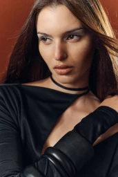 Close-up portrait of model Larissa Schumacher wearing a black top and choker against a warm brown background for Marie Claire Australia.