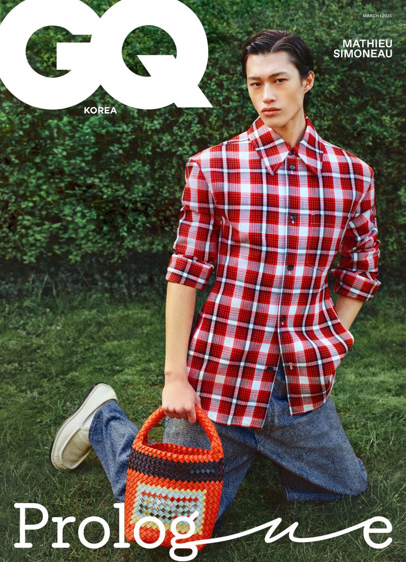 GQ Korea magazine cover featuring a man kneeling in a red and white plaid shirt and jeans, holding an orange woven bag, with green foliage.