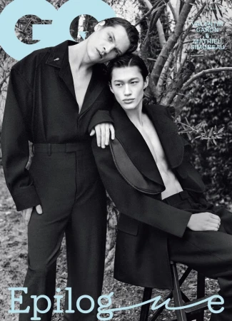 Two male models in black attire posing outdoors against trees for GQ Korea March 2025 magazine cover