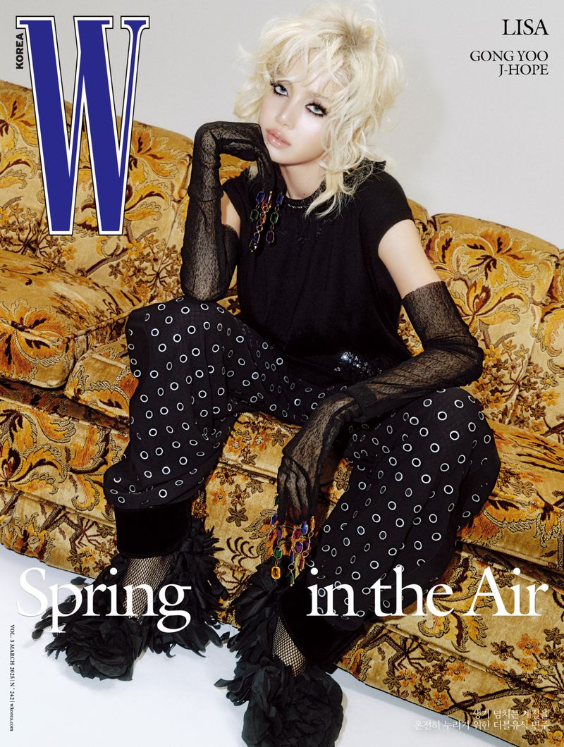Magazine cover featuring a woman with blonde hair in a black top, patterned pants, and gloves, posing on a patterned sofa.