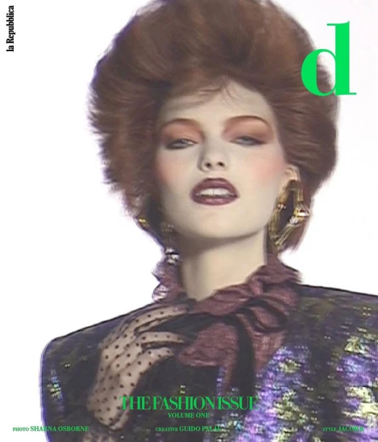 Fashion magazine cover features a woman with voluminous red hair, bold makeup, large gold earrings, and a shimmering jacket.